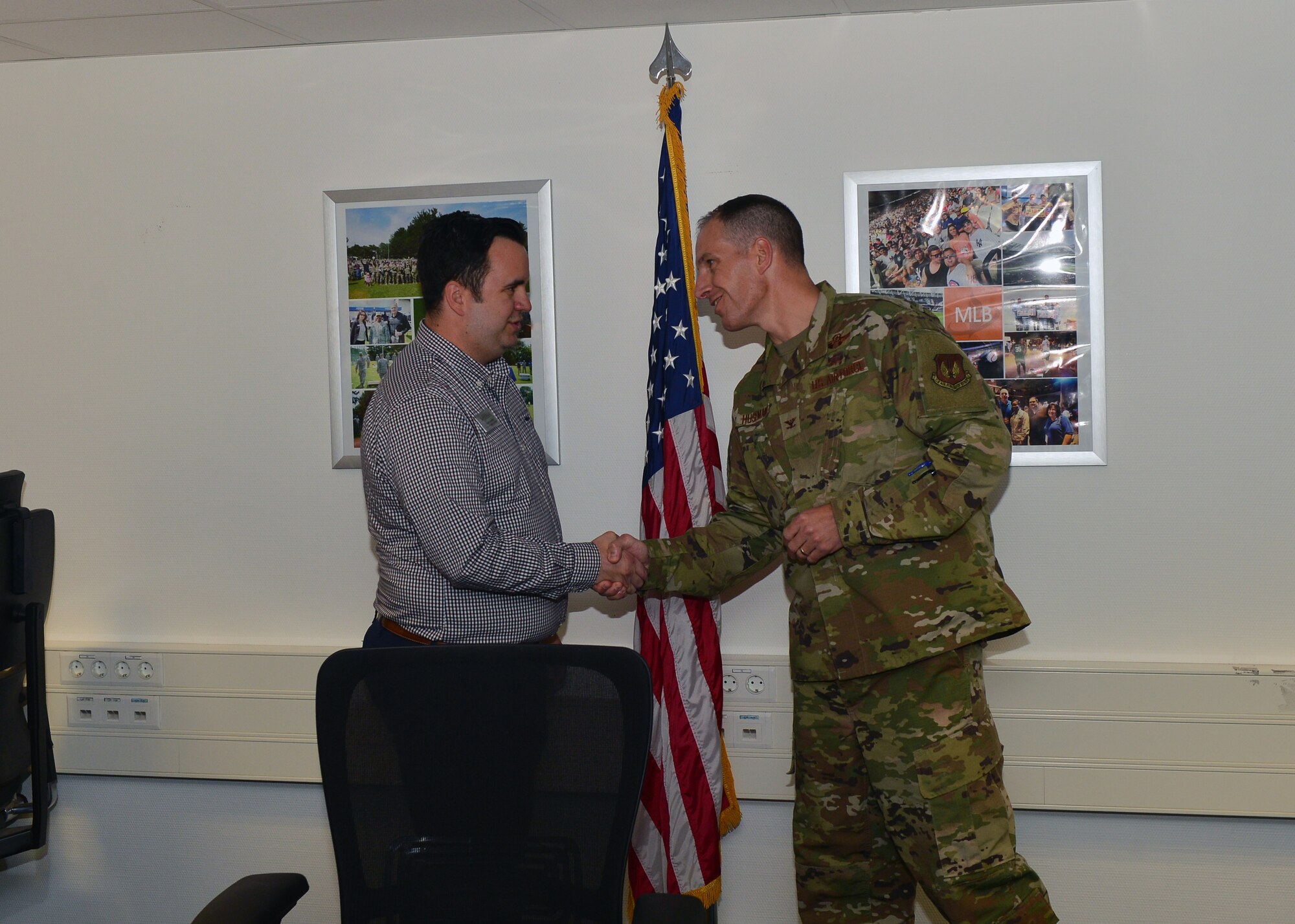 U.S. Air Force Col. Matt S. Husemann, 86th Airlift Wing vice commander, presents Steven Sarandos, 86th Force Support Squadron community cohesion coordinator, with the Airlifter of the Week coin at Ramstein Air Base, Germany, Oct. 2, 2019. Sarandos was recognized for his work in coordinating morale events for Airmen to help them build and maintain resiliency. (U.S. Air Force photo by Staff Sgt. Jimmie D. Pike)