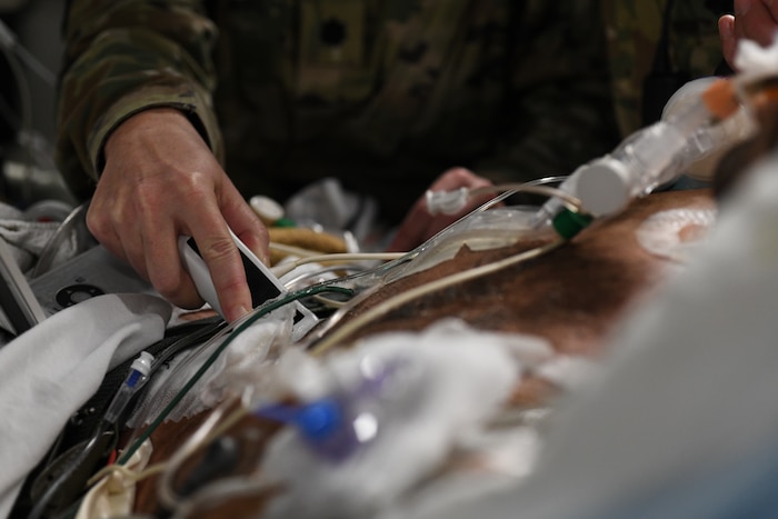 Lt. Col. Valerie Sams, 59th Medical Wing trauma surgeon, performs an ultrasound to monitor a patient during a 20-hour direct flight from Bagram Airfield, Afghanistan to San Antonio, Texas, Aug. 18, 2019. This unique aerial mission providing around-the-clock patient care was refueled twice in-air, supported by multiple pilots, aircrew and joint service teams of medics working in shifts to maintain the highest level of care possible. (U.S. Air Force photo by Airman 1st Class Ryan Mancuso)