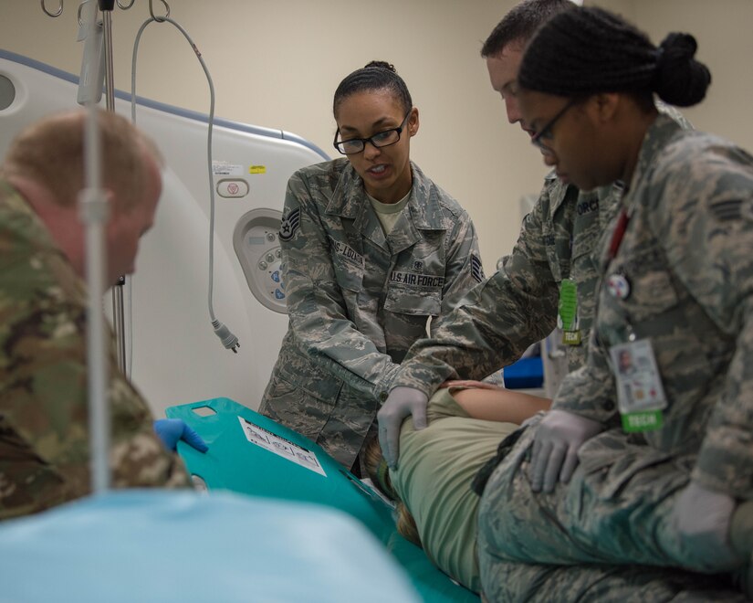 Members of the 633rd Surgical Operations Squadron roll a simulated patient onto a backboard for easier transport during radiology trauma training on Joint Base Langley-Eustis, Virginia, Sept. 26, 2019. During radiology trauma training, members of the 633rd SGCS practiced different techniques for treating simulated patients with back injuries and arm injuries. (U.S. Air Force photo by Airman 1st Class Marcus M. Bullock)