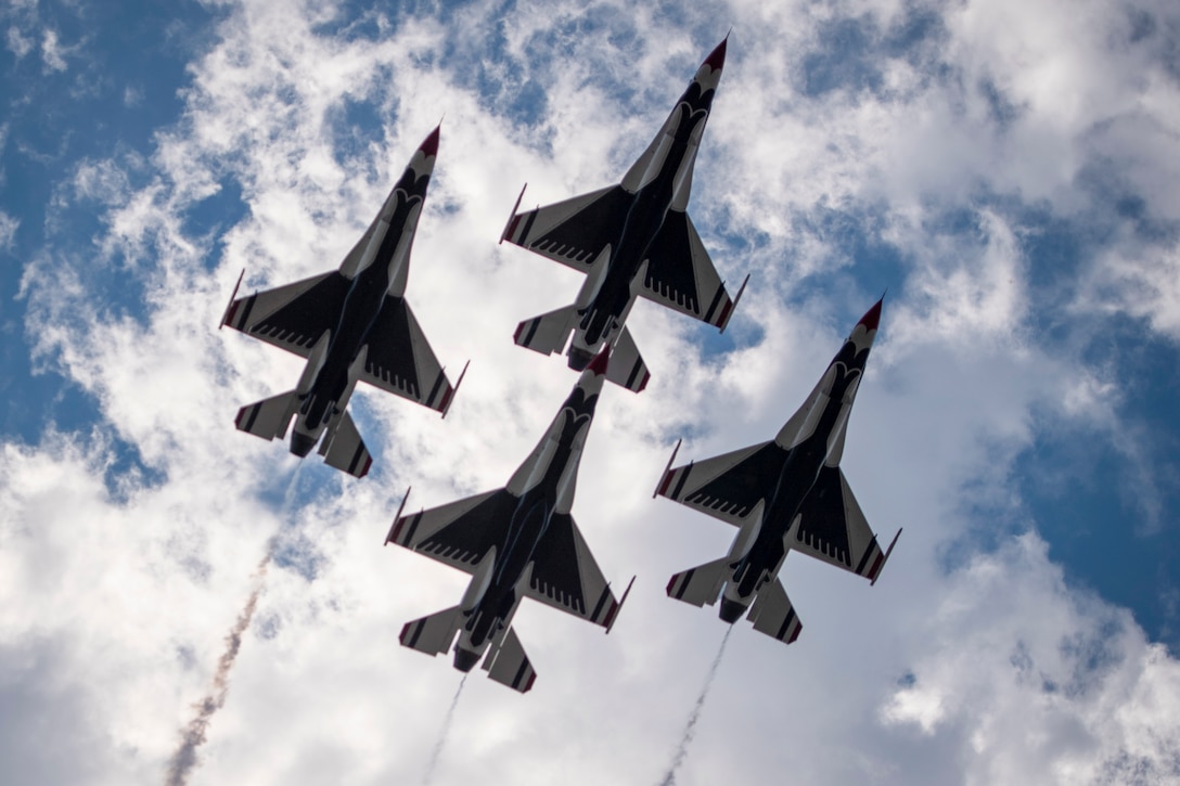 A look underneath as four planes fly in a diamond formation.