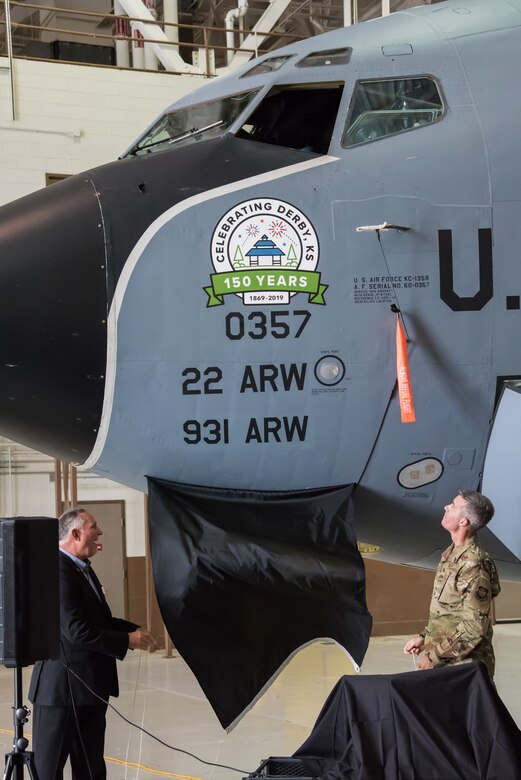 Colonel Richard Tanner, 22nd Air Refueling Wing commander, and Randy White, Mayor of Derby and 931st Operations Group honorary commander, unveil the KC-135 Stratotanker nose art dedicated to the city of Derby’s 150th anniversary Oct. 2, 2019, at McConnell Air Force Base, Kan. The event promoted partnership between the local community and military members, while also honoring their long history together. (U.S. Air Force photo by Senior Airman Skyler Combs)