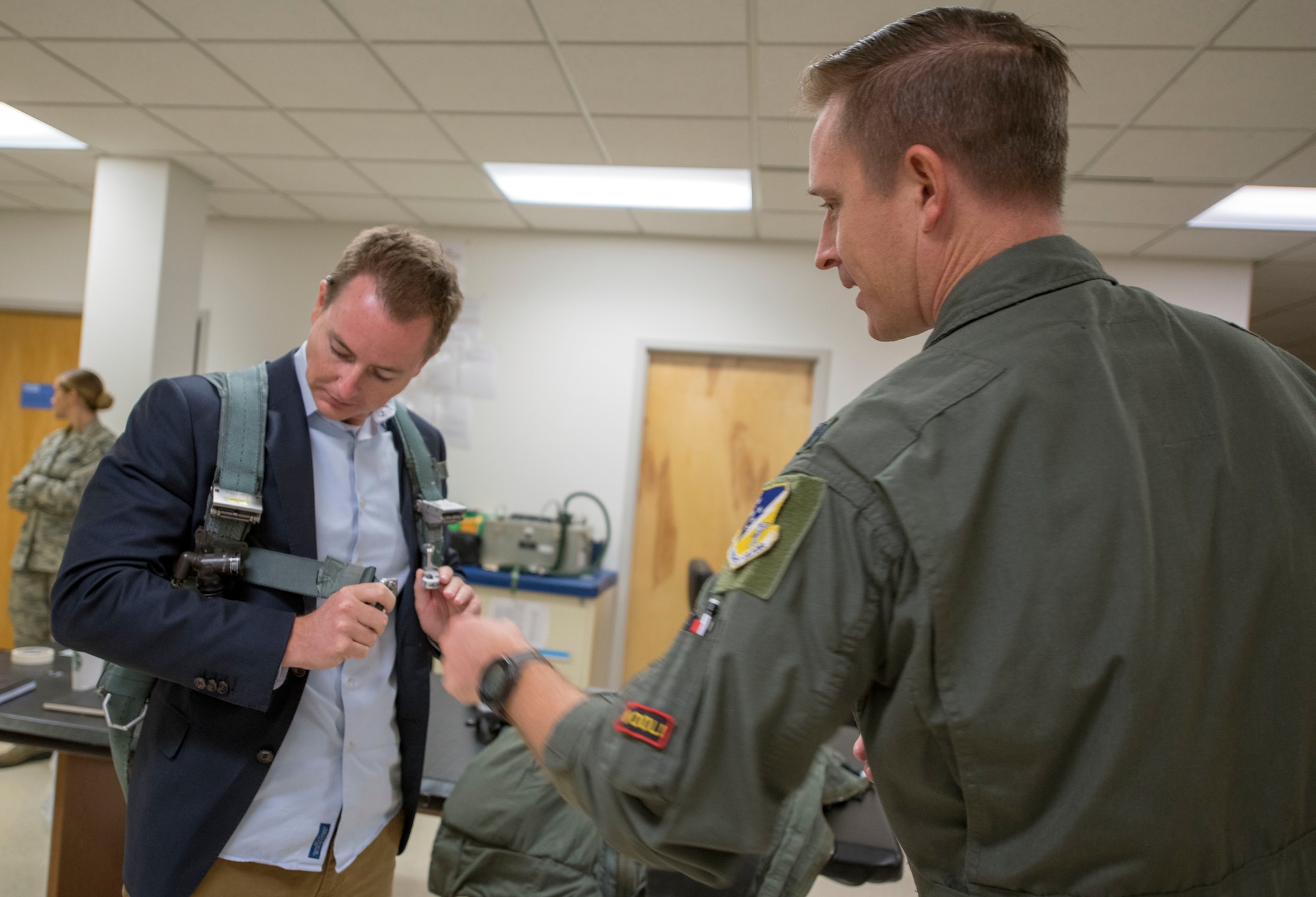 Lt. Col. Christopher Finch, 8th Fighter Squadron commander shows Sean Duggan, congressional staff for Senator Martin Heinrich, a pilot’s harness, Oct. 2, 2019, on Holloman Air Force Base, N.M. Staffers visited to understand the mission of the 49th Wing, which graduates combat ready aircrews and enabling support to various mission partners and tenant units. (U.S. Air Force photo by Staff Sgt. Christine Groening)