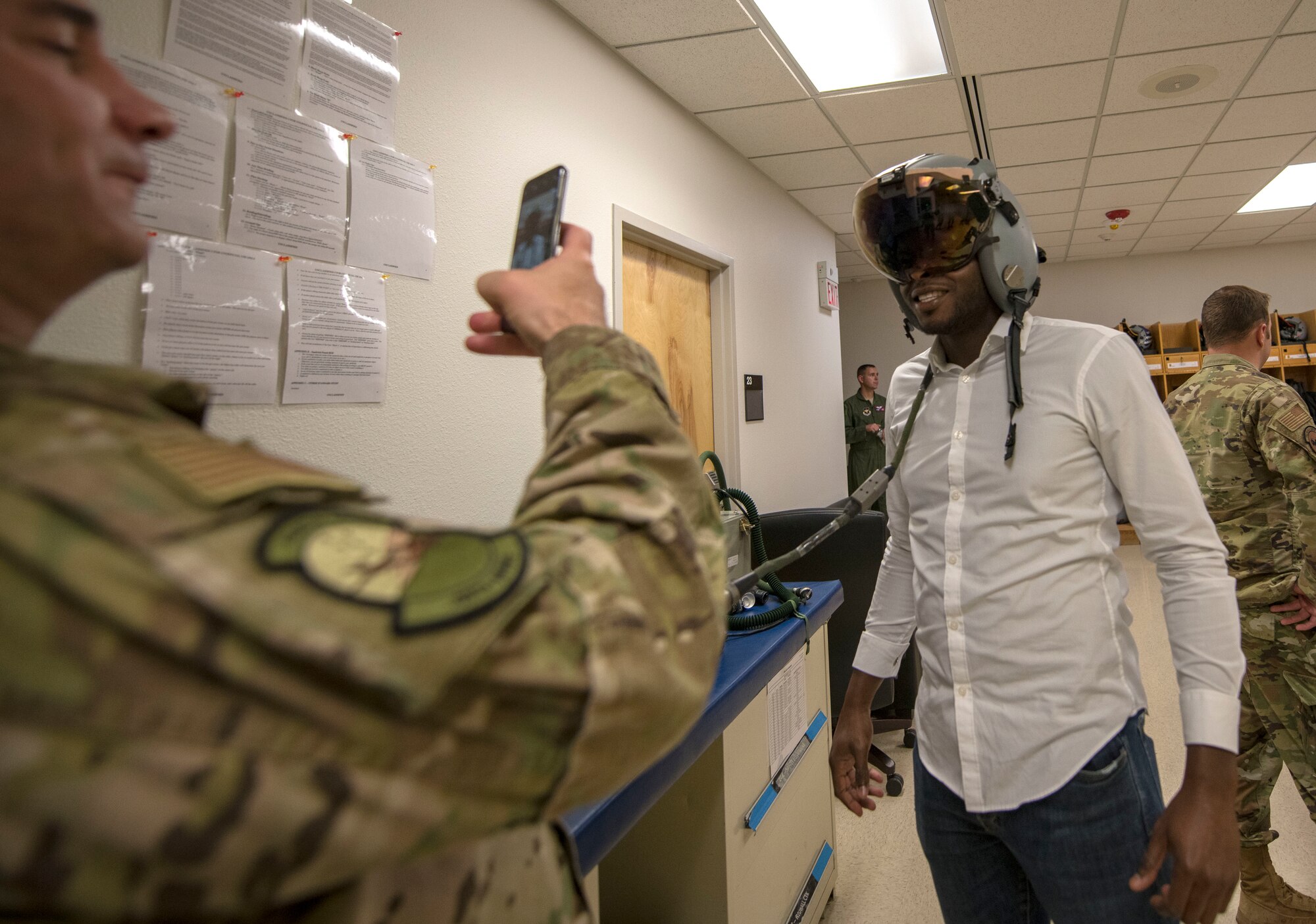 Col. Joseph Campo, 49th Wing commander, takes a photo of Yves Zamar, congressional staff representative for Congresswoman Deb Haaland, in a helmet, Oct 2, 2019, on Holloman Air Force Base, N.M. Staffers visited to better understand the Holloman mission and its role within New Mexico. (U.S. Air Force photo by Staff Sgt. Christine Groening)