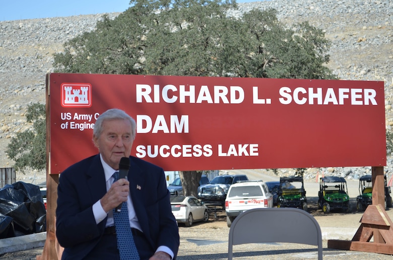 man speaks in front of sign