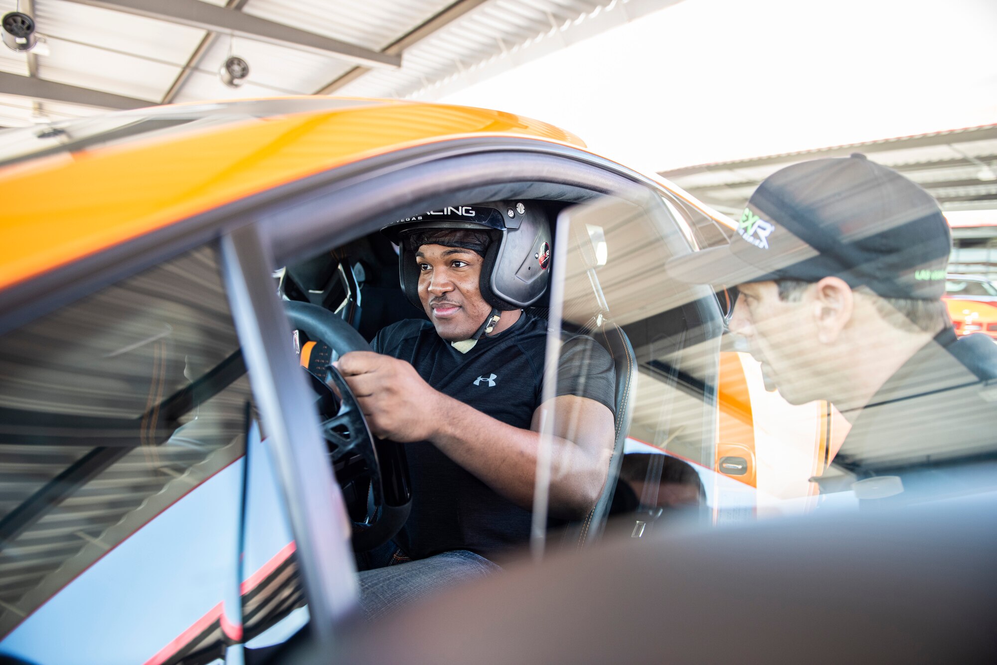 An Airman sits in a Lamborghini at a race track