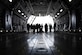 A gaggle of civilians and military members are silhouetted against the bright sunlight outside of the C-5M Super Galaxy in which they currently stand