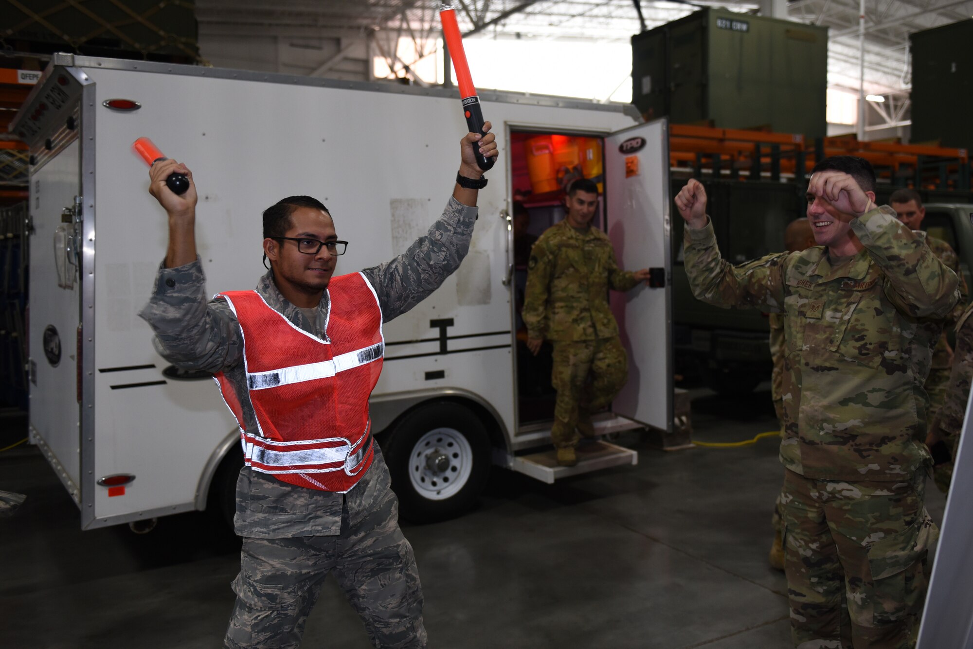 U.S. Air Force Staff Sgt. Craig Usher, right, 821st Contingency Response Squadron C-5 crew chief, teaches Senior Airman Jose Cancel 60th Medical Support Squadron medical logistics technician, how to marshal an aircraft after it lands during the Airmen Enrichment Program Sept. 27, 2019, at Travis Air Force Base, California. The program offers Airmen the opportunity to learn about the numerous specialties the Air Force has to offer. (U.S. Air Force photo by Airman 1st Class Cameron Otte)