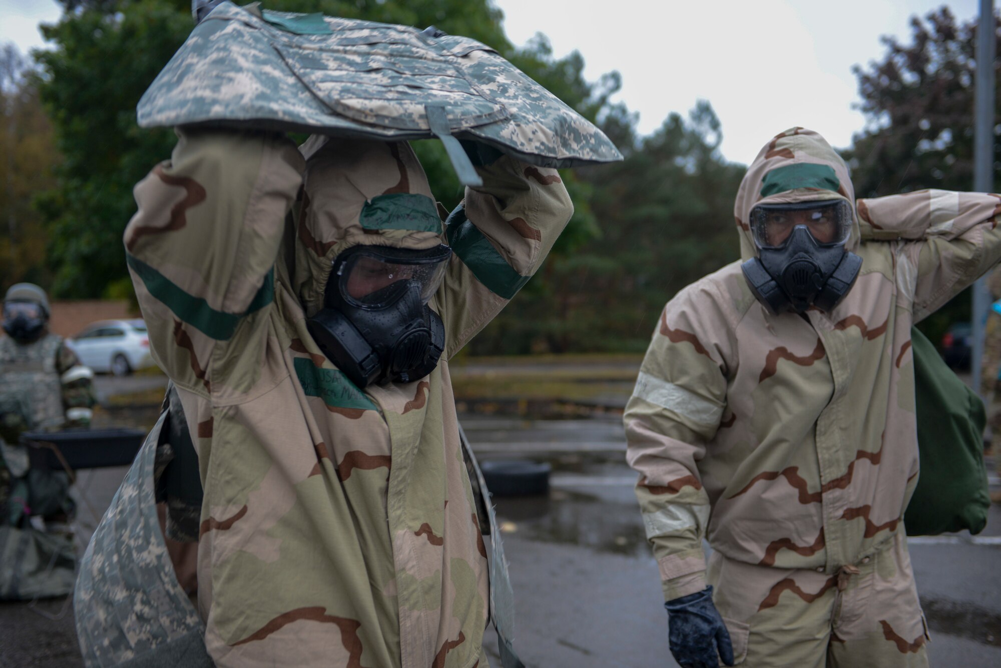 U.S. Airmen doff their individual protective equipment as part of Operation Varsity 19-03 at Ramstein Air Base, Germany, Sept. 27, 2019. Airmen assigned to both the 86th Airlift Wing and 521st Air Mobility Operations Wing simulated decontaminating their equipment to become more familiar with the process. (U.S. Air Force photo by Tech. Sgt. Timothy Moore)