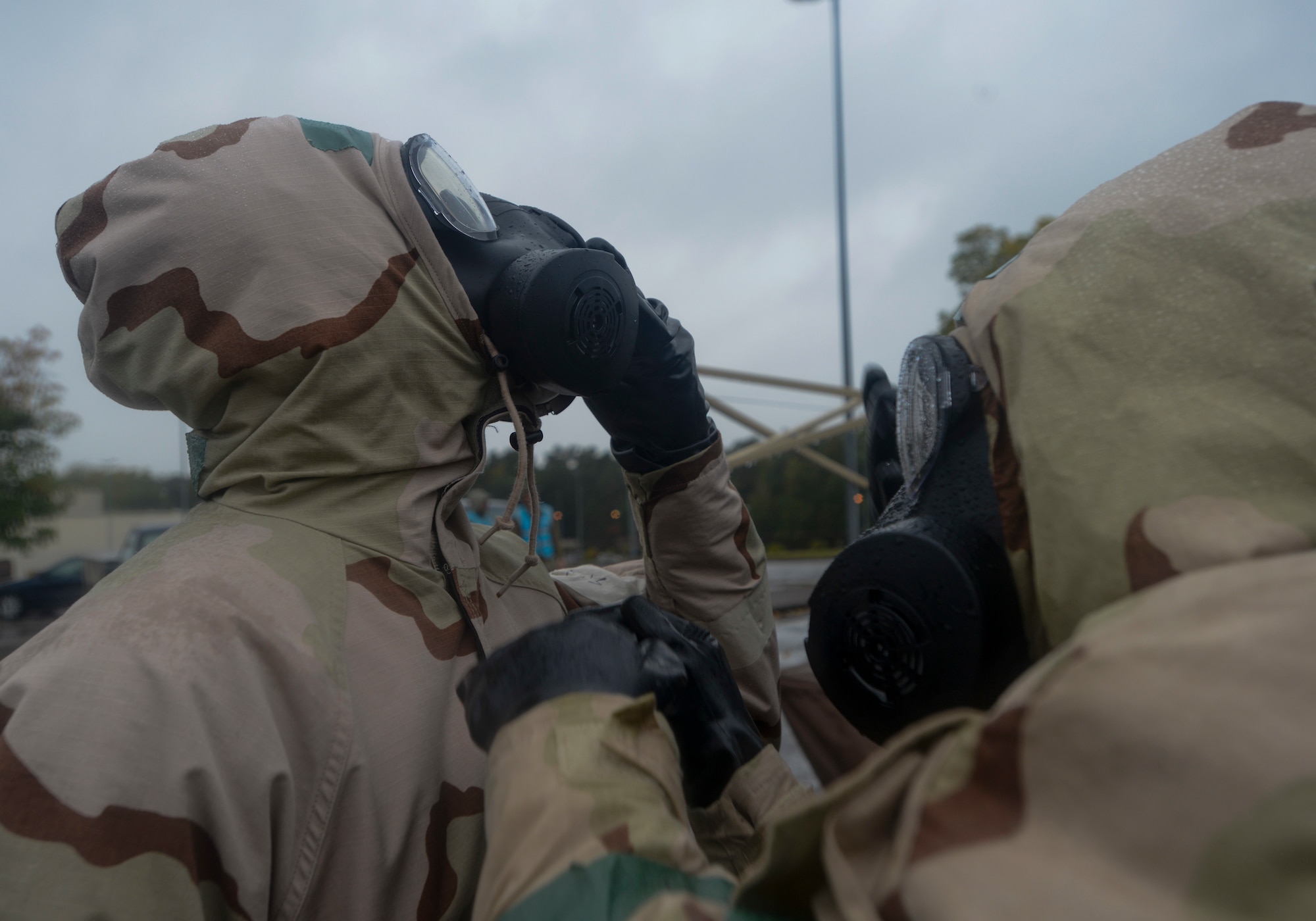 U.S. Airmen assist each other to remove their mission-oriented protective posture gear as part of Operation Varsity 19-03 at Ramstein Air Base, Germany, Sept. 27, 2019. Airmen assigned to both the 86th Airlift Wing and 521st Air Mobility Operations Wing simulated decontaminating their equipment to become more familiar with the process. (U.S. Air Force photo by Tech. Sgt. Timothy Moore)