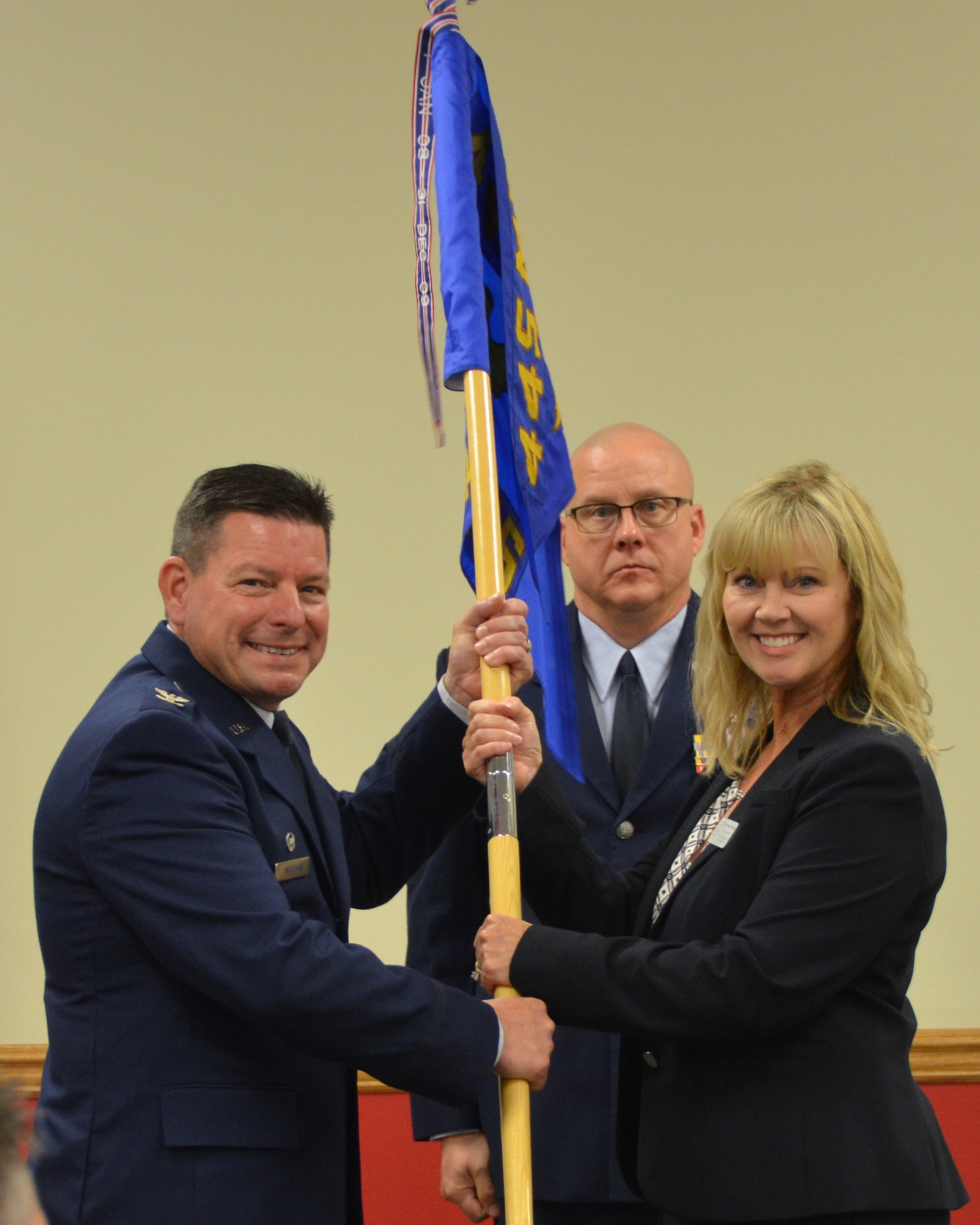 Suzanne Winter, WENCO Construction and honorary commander of the 87th Aerial Port Squadron receives the 87th APS guidon from Col. Shawn Werchan, 445th Airlift Wing vice commander, at the wing’s honorary commanders induction ceremony, Sept. 6, 2019. Eighteen members from the surrounding communities were officially designated as honorary commanders.