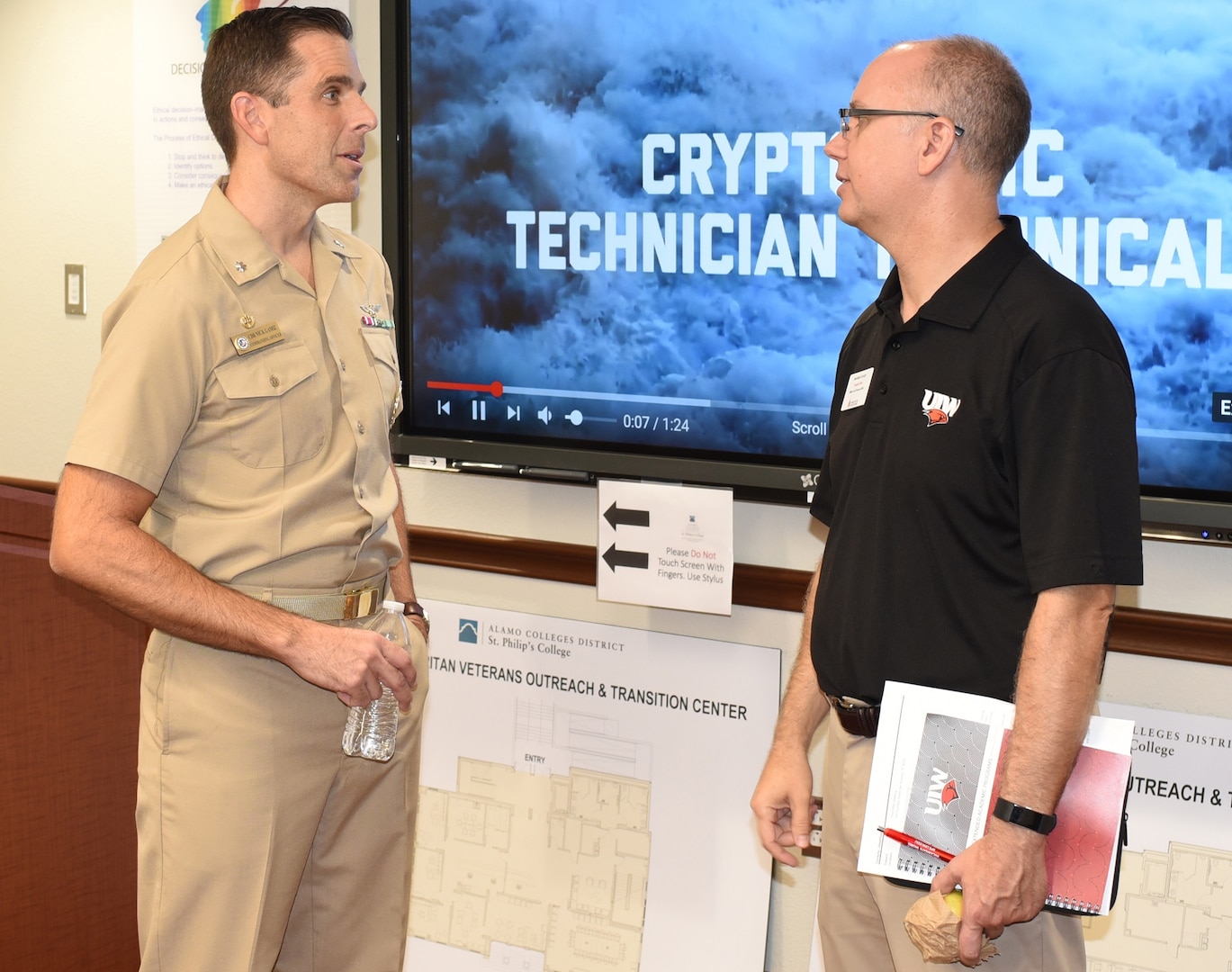 Cmdr. Nicholas Gamiz, commanding officer of Navy Recruiting District San Antonio, speaks with retired Cmdr. Jonathan Lovejoy, an associate dean of Military and Veterans Affairs at the University of the Incarnate Word, during a Recruiting District Assistance Council meeting at St. Philip's College's Good Samaritan Veterans Outreach and Transition Center Sept. 26.