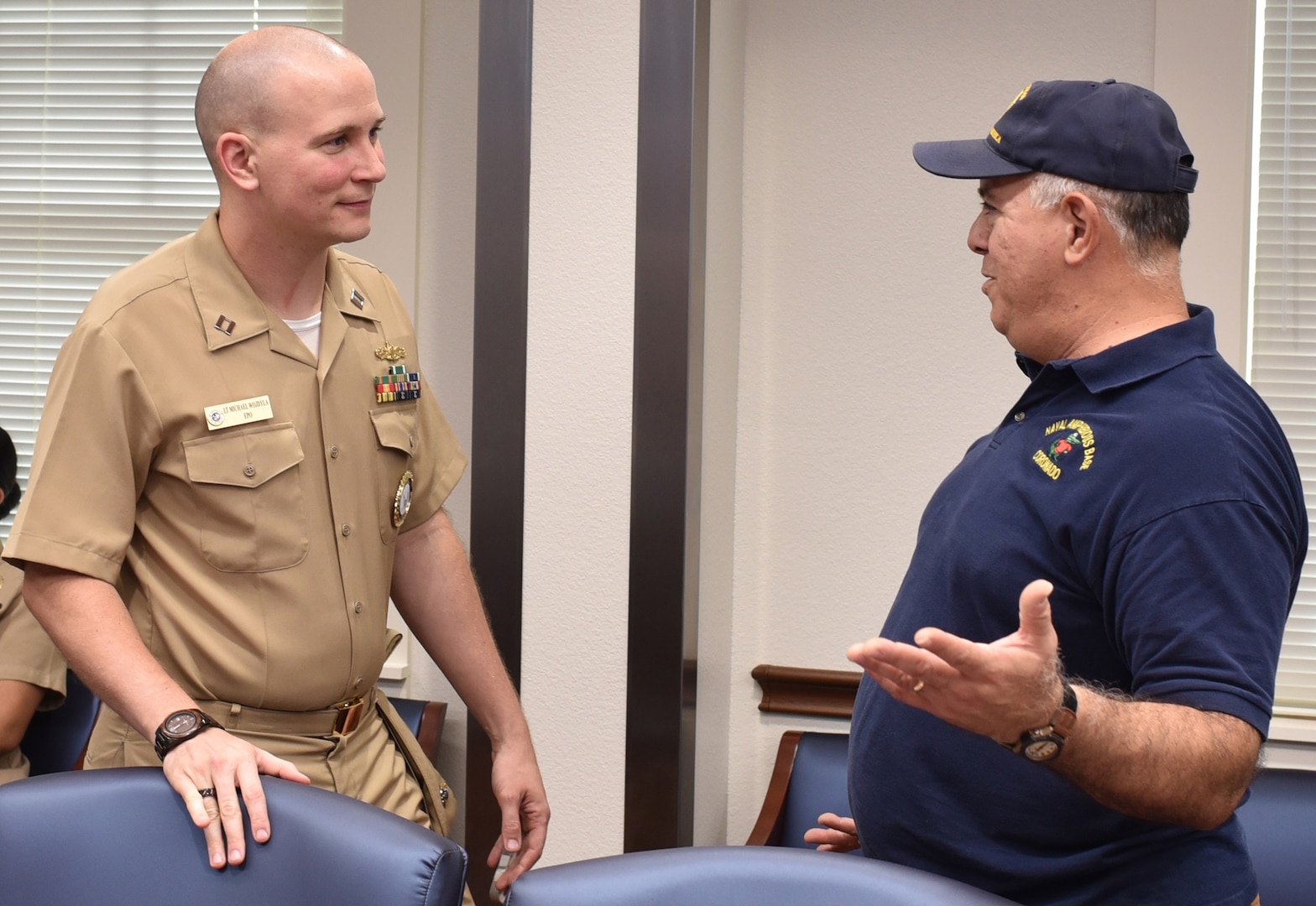 Retired Navy Capt. Humberto Quintanilla II speaks with Lt. Michael Wojdyla, Enlisted Operations Programs officer assigned to Navy Recruiting District San Antonio, during a Recruiting District Assistance Council meeting at St. Philip's College's Good Samaritan Veterans Outreach and Transition Center.