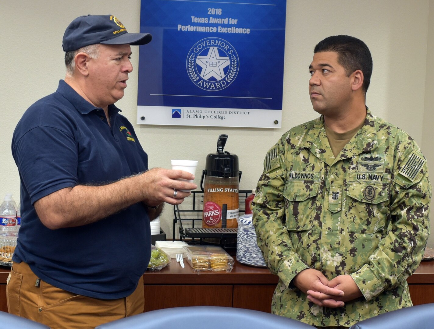 Retired Navy Capt. Humberto Quintanilla II speaks with Command Master Chief Francisco Valdovinos, Navy Recruiting District San Antonio, during a Recruiting District Assistance Council meeting at St. Philip's College's Good Samaritan Veterans Outreach and Transition Center Sept. 26.  RDAC members assist Navy recruiting by joining talents available in Navy-related organizations, the civilian community, and the Naval Reserve.