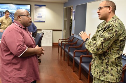 Cmdr. Michael Files, executive officer for Navy Recruiting District San Antonio, speaks with Marine veteran Edward Jones, an instructor at Wagner High School, during a Recruiting District Assistance Council meeting held at St. Philip's College's Good Samaritan Veterans Outreach and Transition Center Sept. 26.