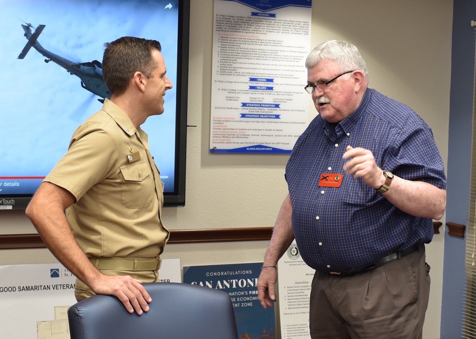 Retired Army Maj. James Cunningham, federal and state legislator for the Military Officers Association of America-Alamo Chapter, speaks with Cmdr. Nicholas Gamiz, commanding officer of Navy Recruiting District San Antonio, during a Recruiting District Assistance Council meeting held at St. Philip's College's Good Samaritan Veterans Outreach and Transition Center Sept. 26. RDAC members assist Navy recruiting by joining talents available in Navy-related organizations, the civilian community, and the Naval Reserve.