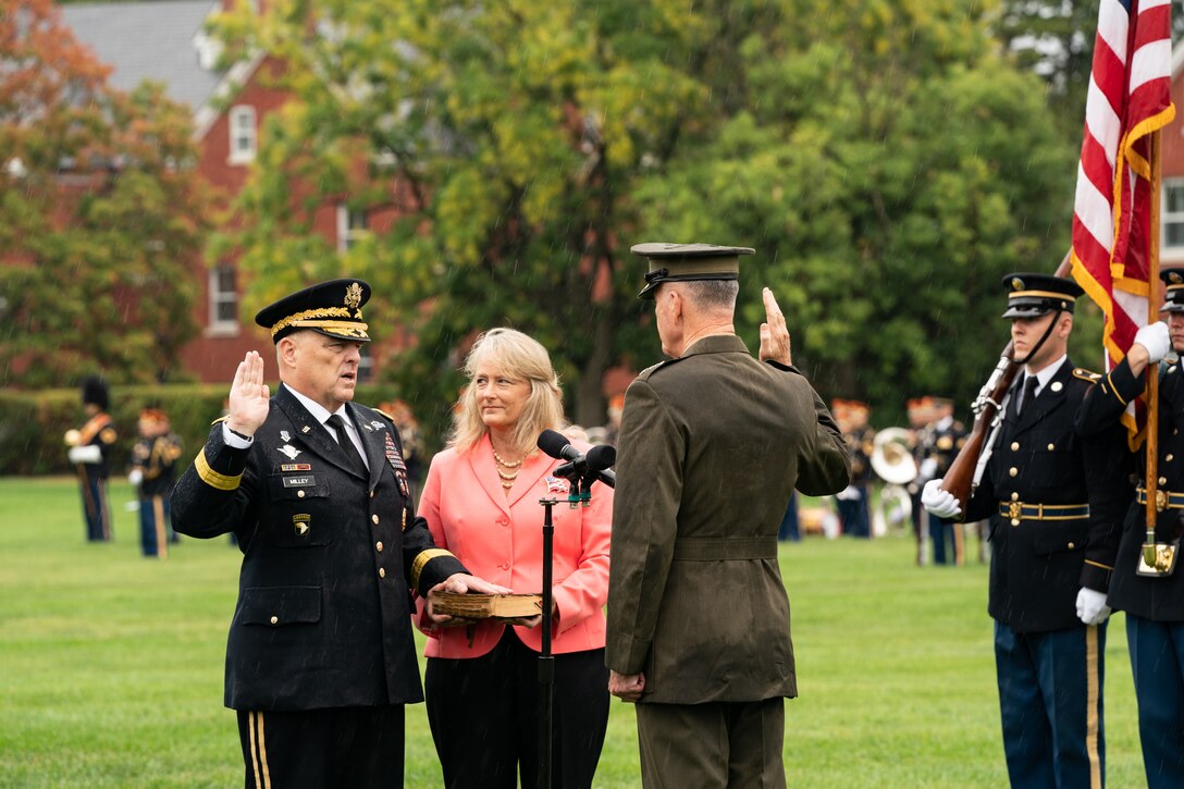 Marine Corps Gen. Joe Dunford and Army Gen. Mark A. Milley stand facing each other with their right hands raised.