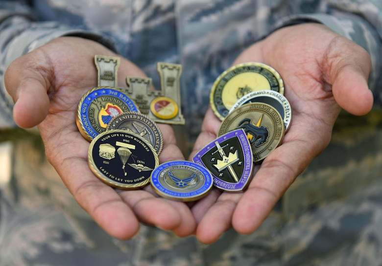 Airman 1st Class Saeed Shnawa, an aircrew flight equipment technician assigned to the 811th Operations Support Squadron on Joint Base Andrews, Md., displays his commemorative coin collection on base, June 6, 2019. Shnawa received coins and letters of commendation for his work with the U.S. and coalition forces during Operation Iraqi Freedom. (U.S. Air Force photo by Senior Airman Alyssa D. Van Hook)