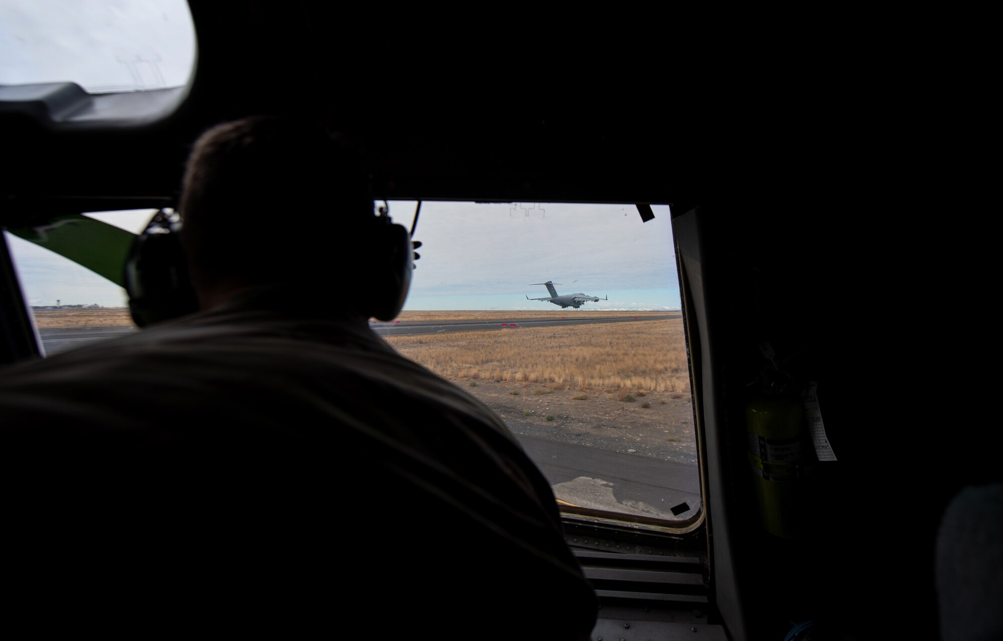 U.S. Army Col. Skye Duncan, Joint Base Lewis-McChord (JBLM) commander, watches a C-17 Globemaster III take off through the window of another C-17 at Moses Lake Municipal Airport, Wash., Oct. 1, 2019. The purpose of the flight was to provide training opportunities for Air Force pilots and Army Soldiers during a mobility movement exercise. (U.S. Air Force photo by Senior Airman Tryphena Mayhugh)