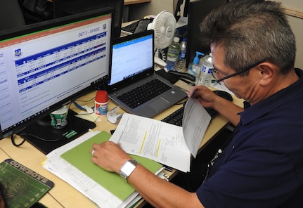 Frank Sinche, an Air Force Installation and Mission Support Center base analyst for Air Force District of Washington and Air Force Special Operations Command units, reviews funding requirements in preparation for briefing members of the war room on closeout status.
