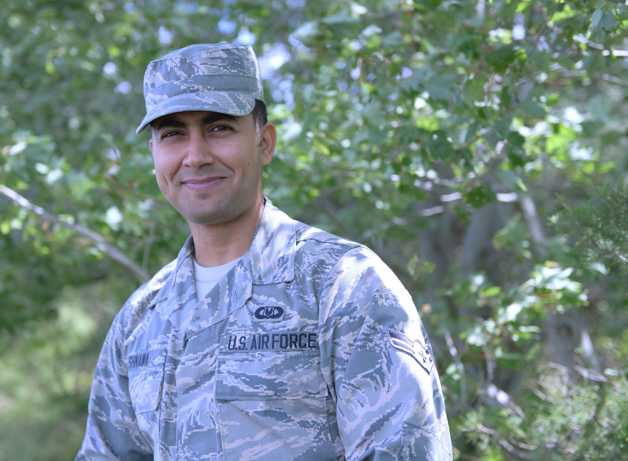Airman in camouflage uniform poses for a casual portrait.