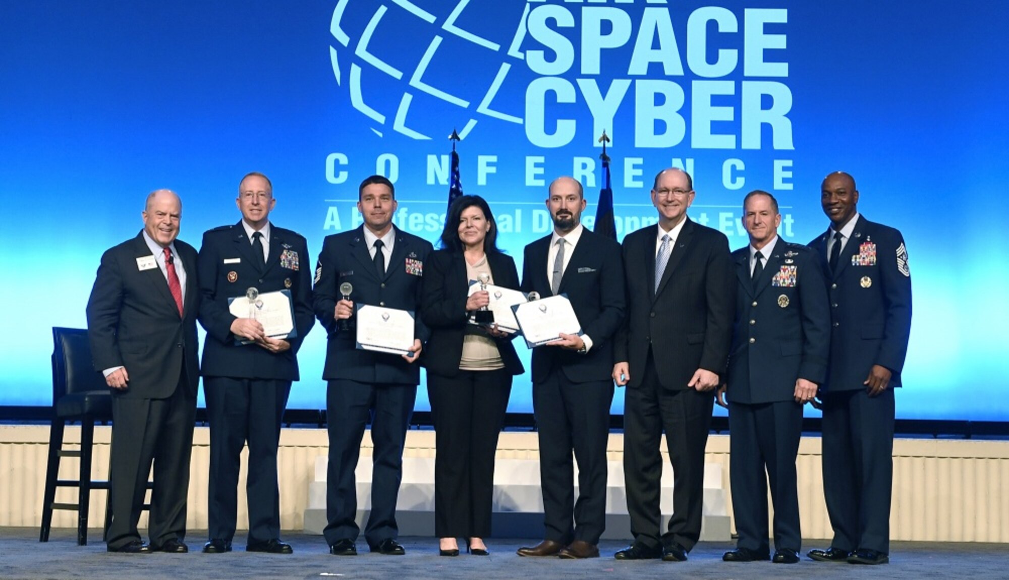 Lt. Col. Andrew Allen, Master Sgt. Kyle Wilson, Jean-Anne Butler and Matthew Bradesca receive the International Affairs Excellence Award from Air Force Chief of Staff Gen. David L. Goldfein, Acting Secretary of the Air Force Matthew Donovan, Chief Master Sgt. of the Air Force Kaleth Wright and Whit Peters, Chairman of the Air Force Association Board, during the Air Force Association Air, Space and Cyber Conference Sept. 16, 2019, in National Harbor, Md.