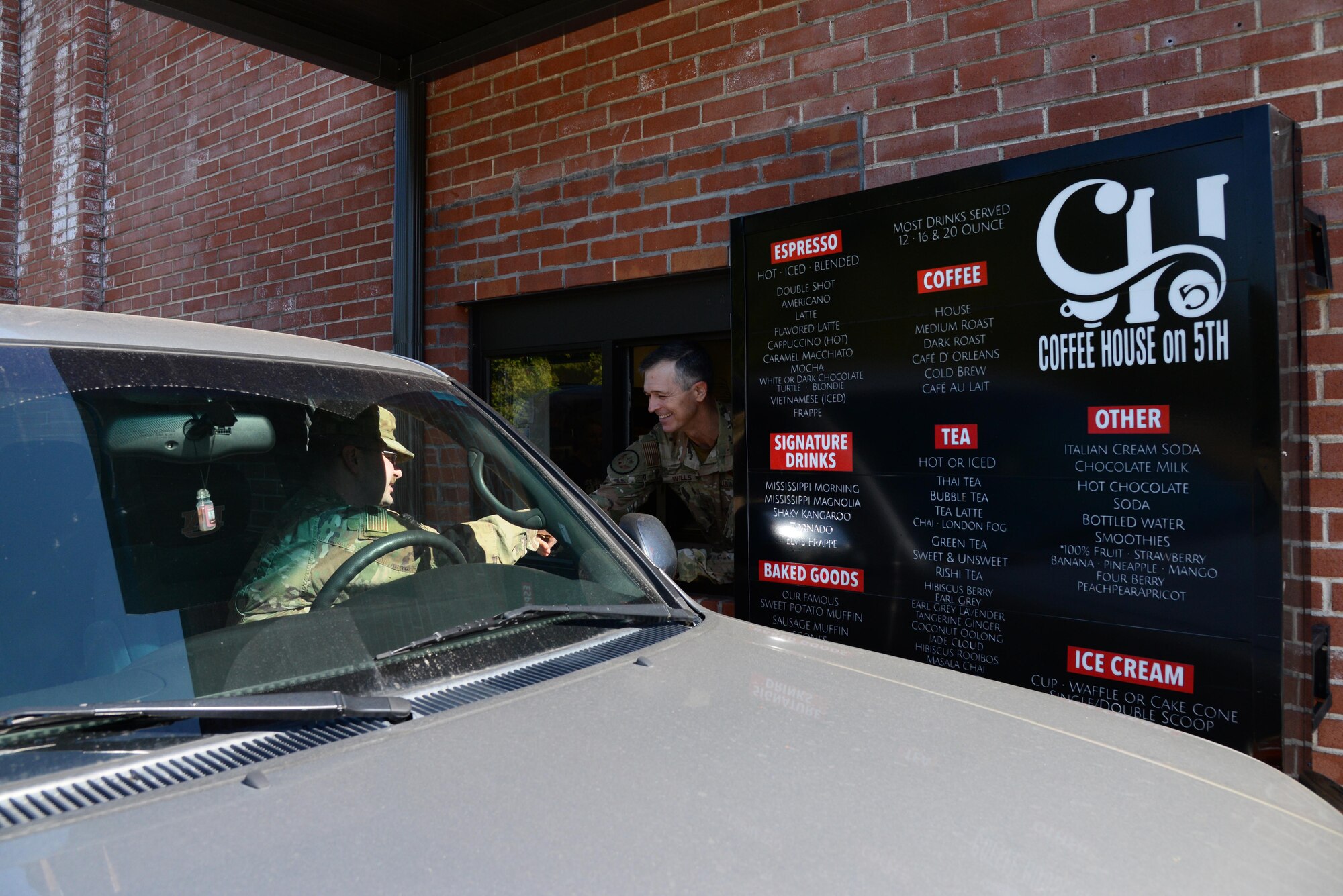 Maj. Gen. Wills, 19th Air Force commander, coins Master Sgt. Christopher Palmer, 14th Contracting Squadron flight chief, through the drive through window of the Coffee House on 5th during a visit to Columbus AFB, Miss., Oct. 1, 2019. Throughout Wills’ visit to Columbus AFB, he recognized outstanding members of Team BLAZE for their contributions and actions toward cultivating Airmen, creating pilots and connecting with one another. (U.S. Air Force photo by Airman 1st Class Jake Jacobsen)