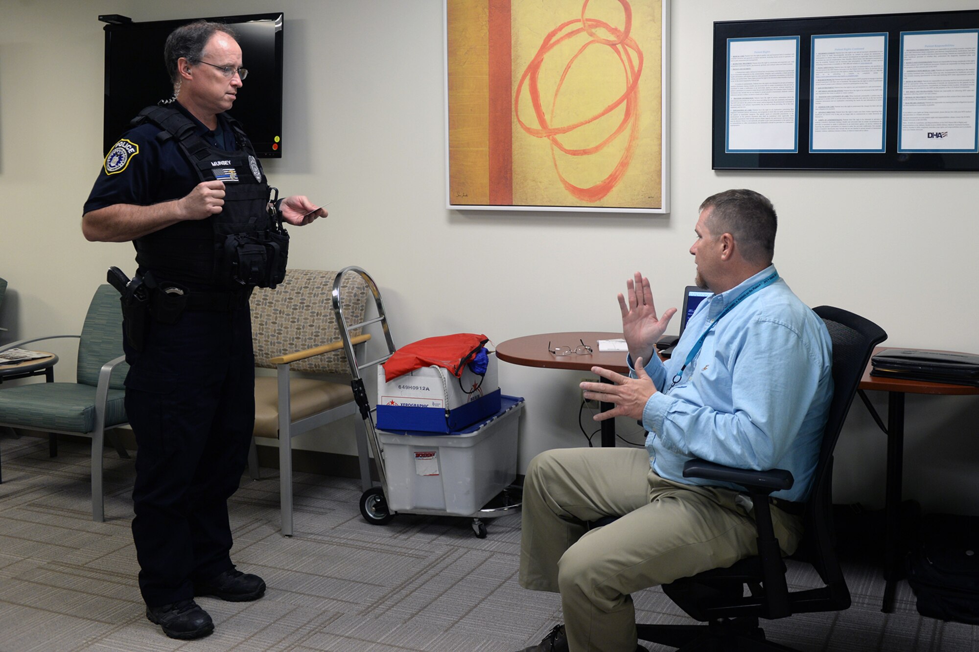 David Conrad VA outreach coordinator sits right and speaks to Police officer James Munsey about VA benefits.