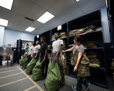 Cecil Harvey, 502d Logistics Readiness Squadron lead supply technician, helps a U.S. Air Force basic military training trainee, 326th Training Squadron, during the initial issue of the first operational camouflage pattern (OCP) uniform, Oct. 2, 2019, at Joint Base San Antonio-Lackland, Texas.