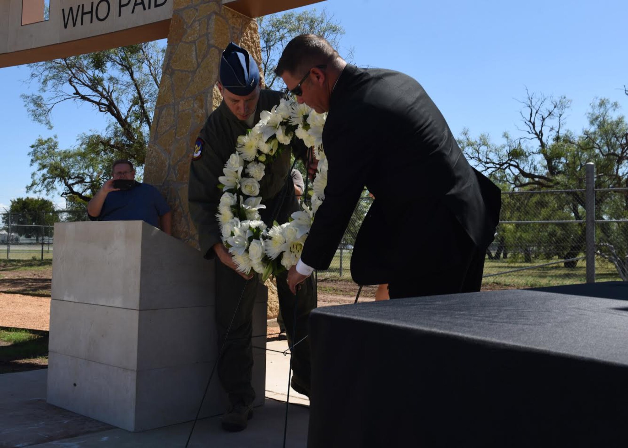 Col. Jeffery Menasco, 317th Airlift Wing commander, middle, and Shawn Martin, 317th Airlift Wing honorary commander, place a wreath next to the TORQE 62 Memorial in Abilene, Texas, Oct. 2, 2019.