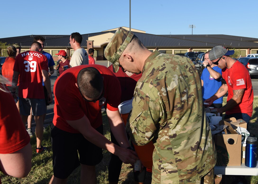 Airmen assigned to Dyess Air Force Base, Texas, stop for water after finishing their run in the TORQE 62 memorial run Oct. 2, 2019.