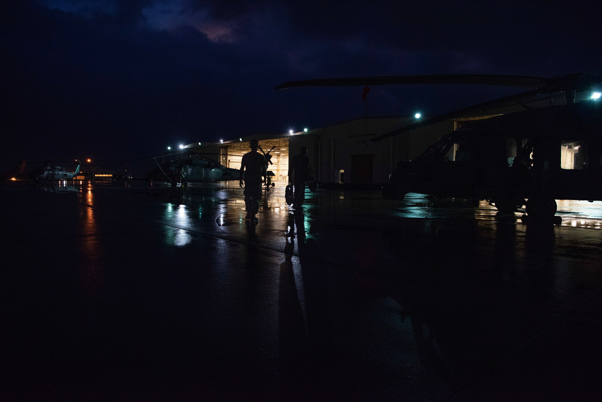 (Left) U.S. Air Force Airman 1st Class Howard Cowell, 33rd Rescue Squadron crew chief, finishes performing preflight safety checks as Lt. Col. Gabriel Brown, 33rd RQS commander, walks out to an HH-60 Pave Hawk before a flight Sept. 19, 2019, at Kadena Air Base, Japan. The HH-60 Pave Hawkhas a hoist capable of lifting up to 600 pounds during personnel recovery missions. (U.S. Air Force photo by Senior Airman Rhett Isbell)