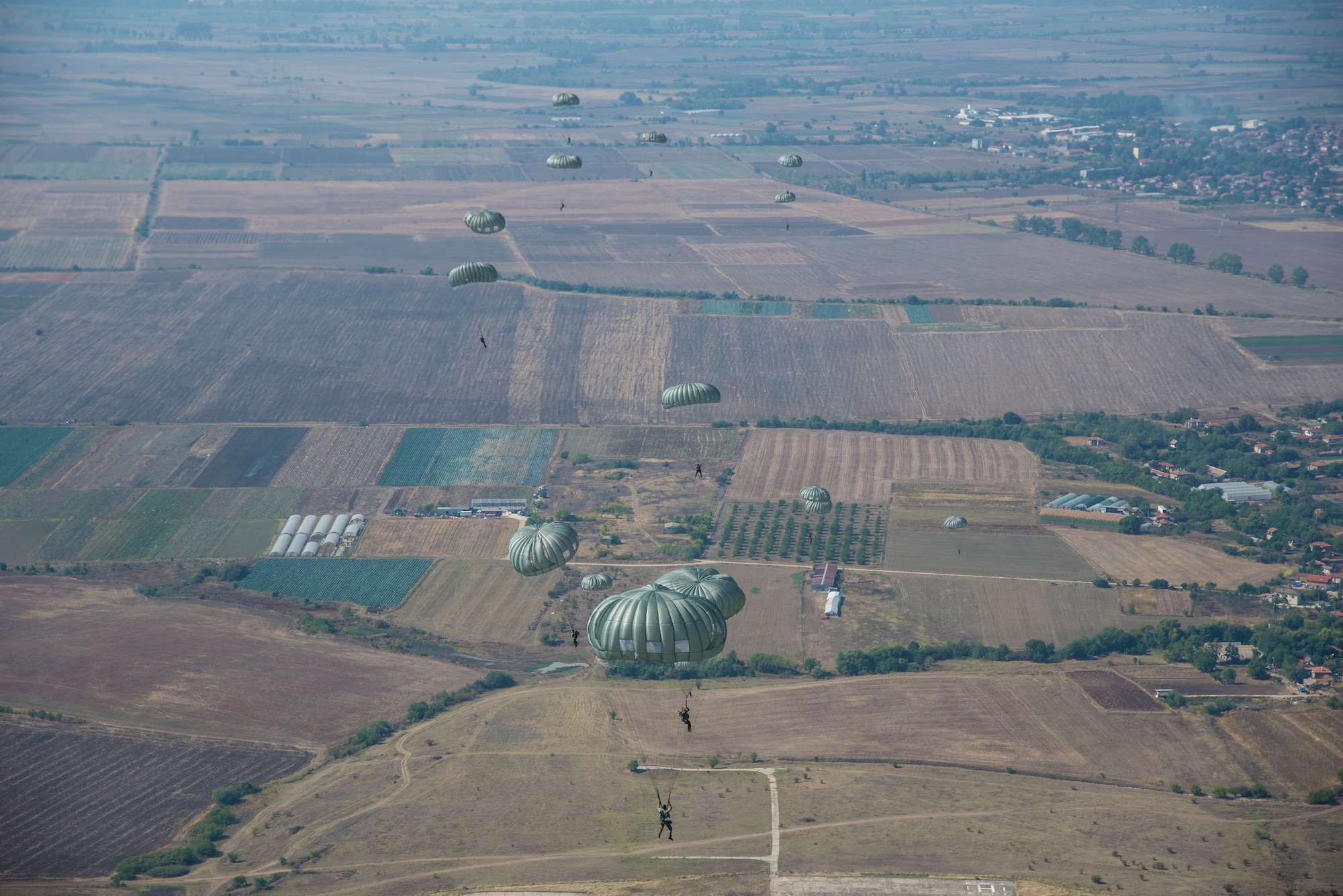 A group of Bulgarian paratroopers descend into Cheshnegirovo drop zone after performing a static-line jump in Plovdiv, Bulgaria, Oct. 2, 2019. During Thracian Fall, the 37th Airlift Squadron provided primary airlift support to a U.S.-sponsored military free-fall course for Bulgaria’s 68th Special Forces Brigade, resulting in a total of 121 personnel drops. (U.S. Air Force photo by Staff Sgt. Kirsten Brandes)
