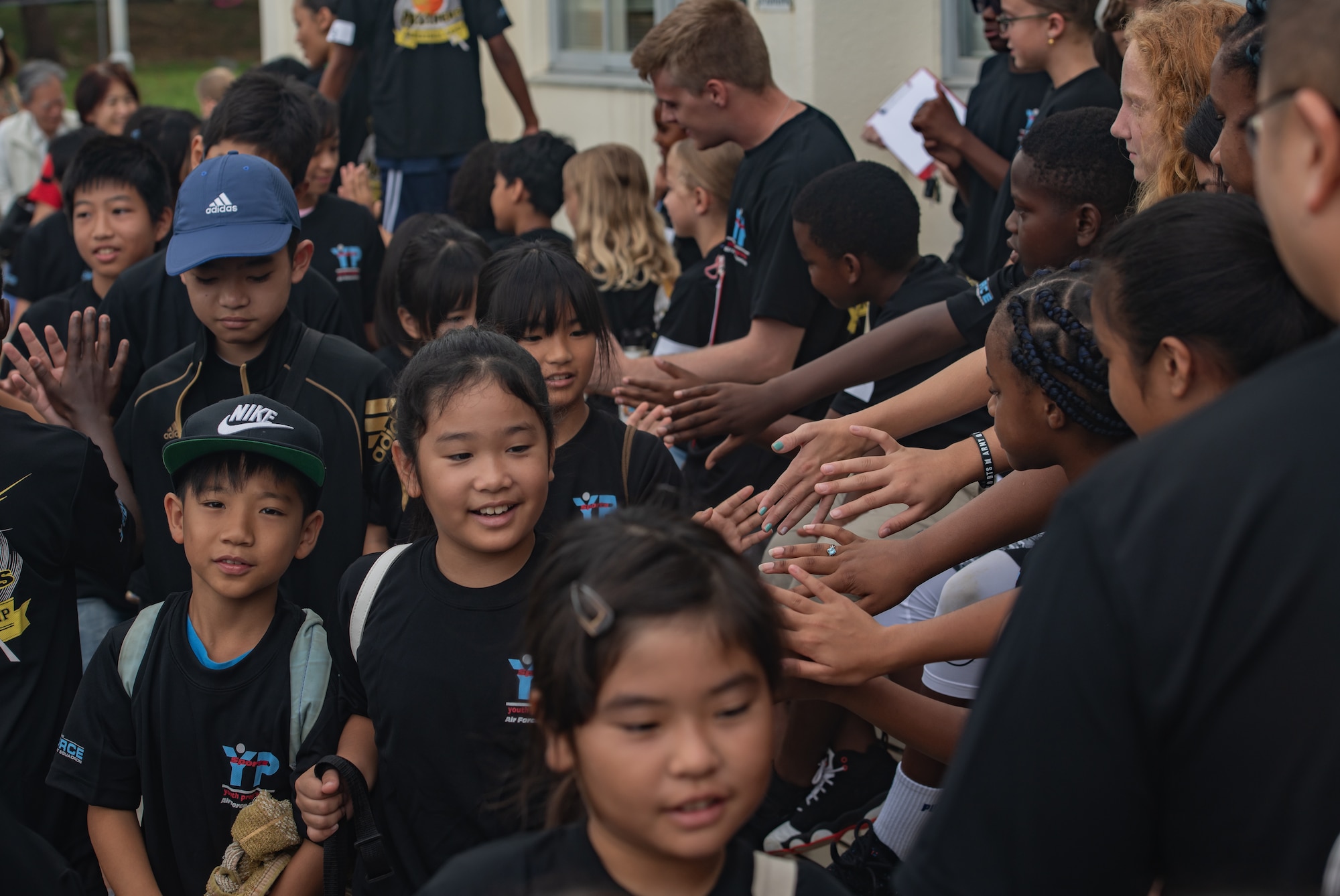 Children from the Kadena Youth Center welcome Okinawan children for Cultural Exchange Day, Sept. 28, 2019, at Kadena Air Base, Japan. The event enabled 49 children from Okinawa and the military community to play and interact with each other through a variety of American and Japanese games and challenges. (U.S. Air Force photo by Staff Sgt. Micaiah Anthony)