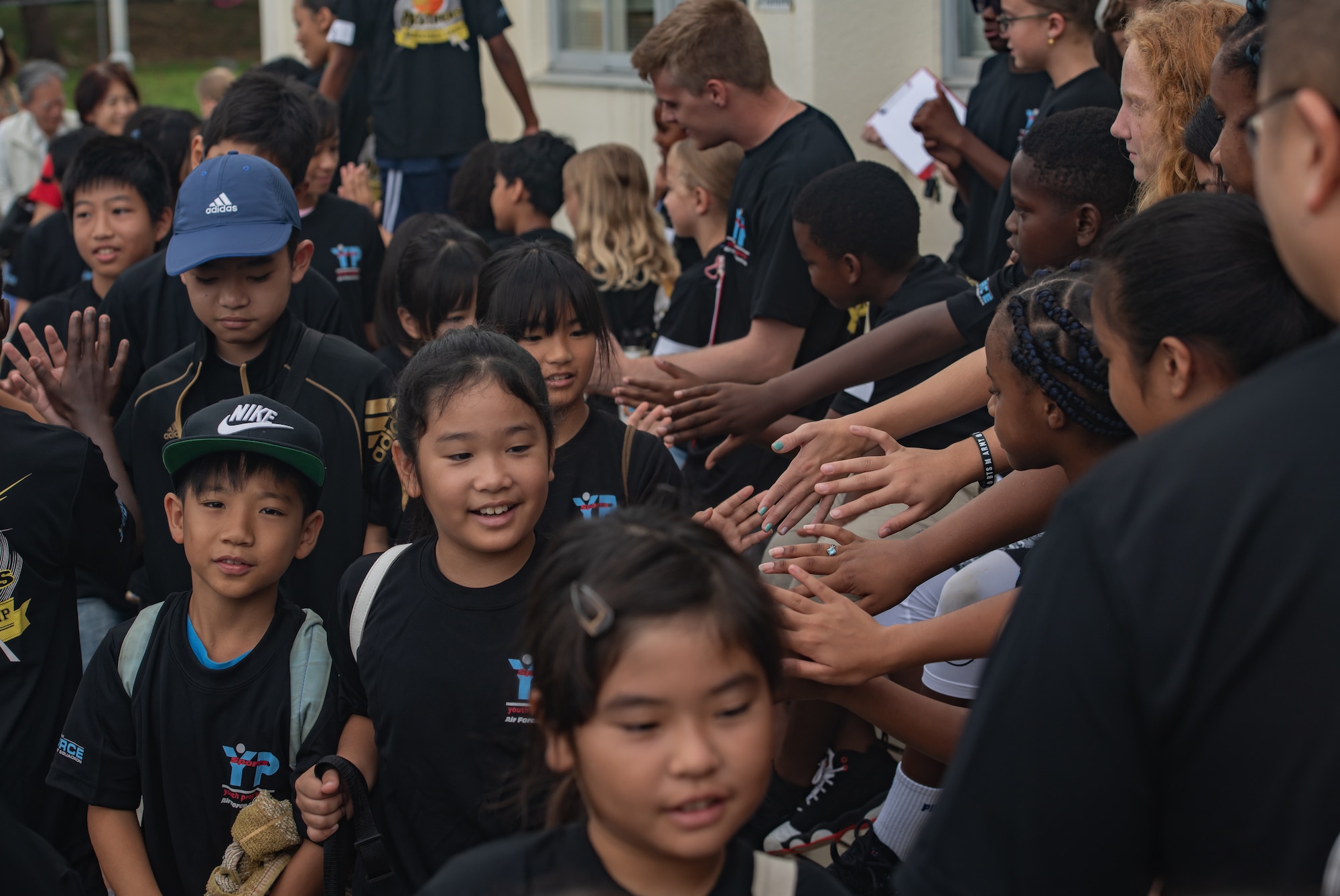 Children from the Kadena Youth Center welcome Okinawan children for Cultural Exchange Day, Sept. 28, 2019, at Kadena Air Base, Japan. The event enabled 49 children from Okinawa and the military community to play and interact with each other through a variety of American and Japanese games and challenges. (U.S. Air Force photo by Staff Sgt. Micaiah Anthony)
