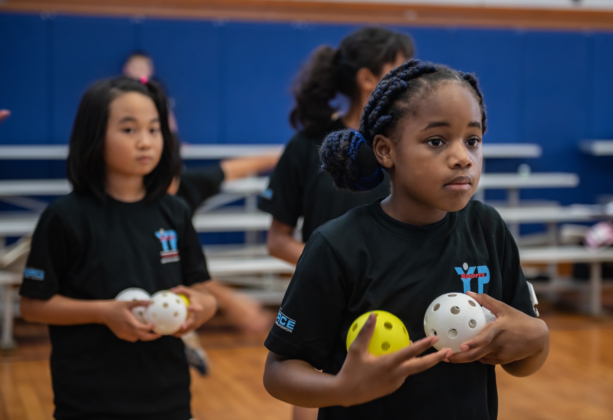 Children throw balls in a bucket as a part of a team building challenge during Cultural Exchange Day, Sept. 28, 2019, at Kadena Air Base, Japan. The children played a variety of games and challenges to learn about each other’s culture and develop friendships. (U.S. Air Force photo by Staff Sgt. Micaiah Anthony)