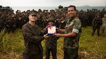 U.S. Marine Lt. Col. Todd Jacobs, the Commander of Toops for 3rd Marine Division during exercise Tiger Strike 19, presents a gift to the Malaysian Armed Forces at Blue Beach, Malaysia, on Oct. 2, 2019. Tiger Strike 19 focuses on strengthening joint military interoperability and on increasing readiness by practicing for humanitarian assistance, disaster relief, amphibious and jungle warfare operations, all while fostering cultural exchanges between the MAF and the U.S. Navy, Marine Corps team. (U.S. Marine Corps photo by Cpl. Josue Marquez)