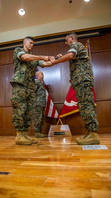 U.S. Marine Corps Brig. Gen. Mark A. Hashimoto, left, the commanding general of Force Headquarter Group, passes the noncommissioned officer’s sword to Sgt. Maj. Michael S. Payne, right, the incoming sergeant major of FHG, during a relief and appointment ceremony at Marine Corps Support Facility New Orleans, Oct. 3, 2019. Payne came to Marine Forces Reserve from his previous command of Staff Noncommissioned Officer Academy in Okinawa, Japan, where he served as the director. (U.S. Marine Corps photo by Sgt. Andy O. Martinez)