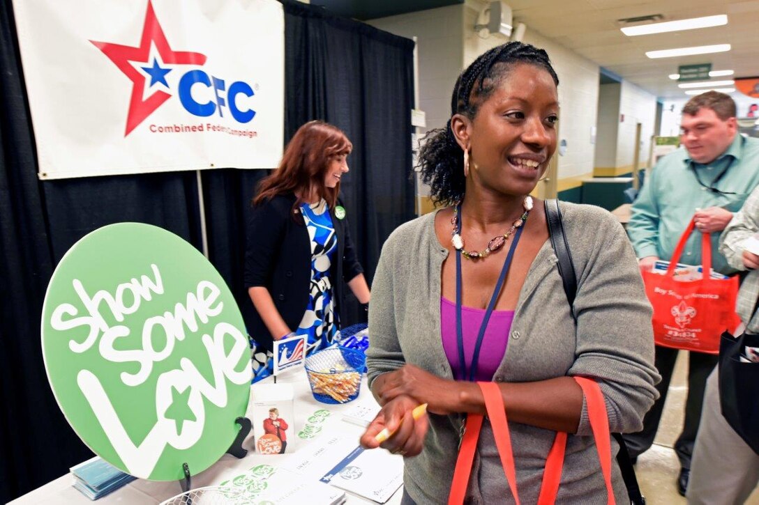 Tracy Weaver, a program manager at the Acquisition, Environmental and Facilities Division, Air Force Life Cycle Management Center, Wright-Patterson Air Force Base, Ohio, visits the Combined Federal Campaign’s own awareness table, staffed by one of last year’s loaned executives, Heather Atkinson, at the Oct. 2 kickoff. (U.S. Air Force photos/Ty Greenlees)