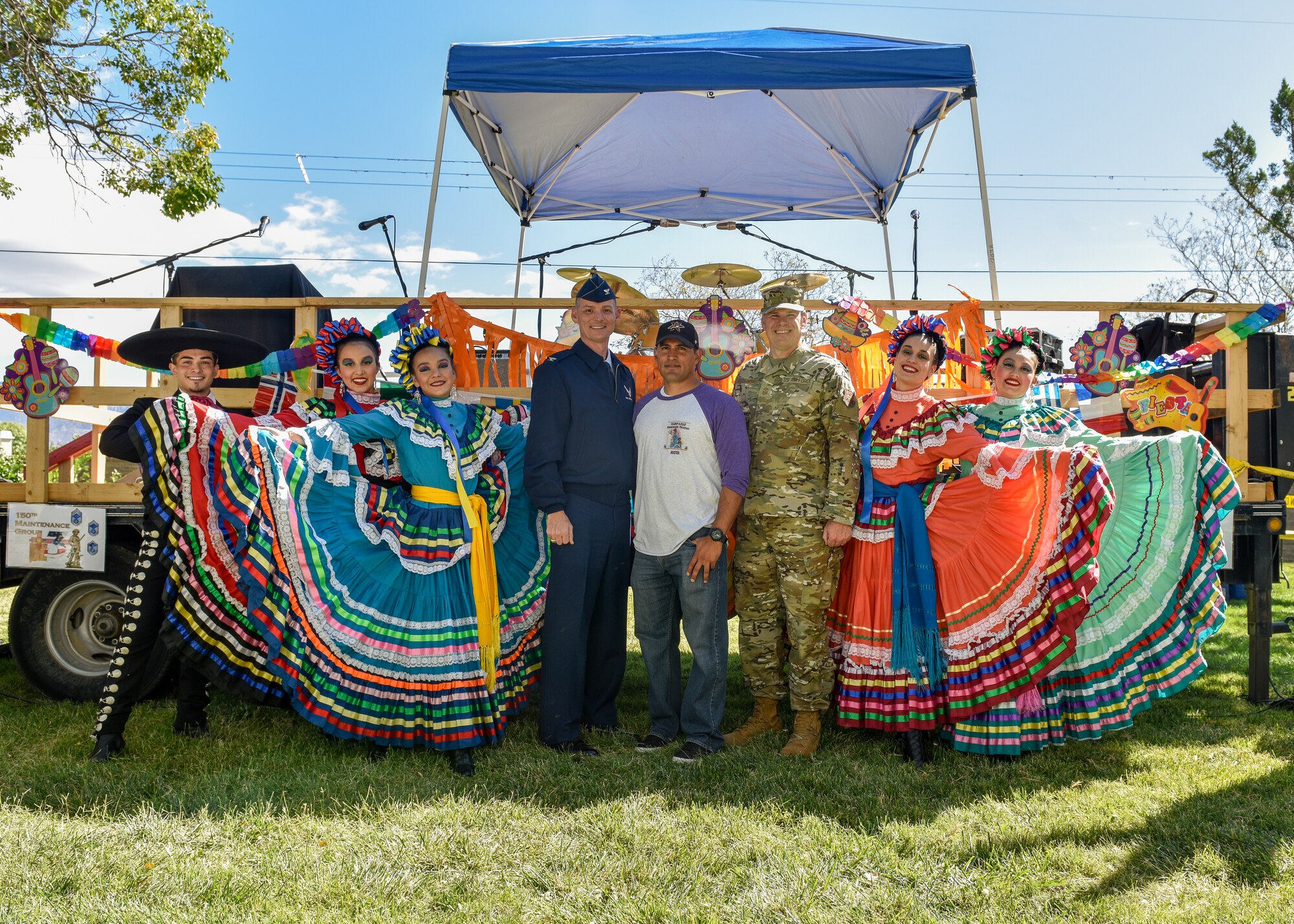 Performers at the Hispanic Heritage Month festival pose for a photo with service members from Team Kirtland at Kirtland Air Force Base, N.M., Oct. 3, 2019. The festival featured live music, folkloric dance, food trucks, information booths, key note speakers and a car show. (U.S. Air Force photo by Airman 1st Class Austin J. Prisbrey)