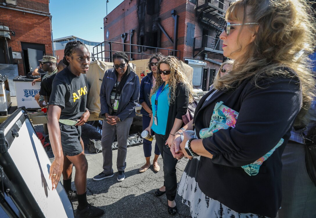 Army Reserve Sgt. Krystal Walton (left), a shift manager and native of Florence, South Carolina, assigned to the 413th Chemical Company, 457th Chemical Battalion, 415th Chemical Brigade, 76th Operational Response Command explains how her unit conducts decontamination operations to a group of civilian medical professionals from the Jacobi Medical Center, at the New York Fire Department Training Academy on Randall's Island, New York, Sept. 27. The training was part of a two-day consequence management training exercise focused on mass casualty decontamination, Chemical, Biological, Radiological and Nuclear (CBRN) reconnaissance and medical operations along side multiple civilian agencies in and around New York City. The training involved various scenarios including rescuing patients from a Subway disaster and decontamination operations at a local hospital. (Official U.S. Army Reserve photo by Sgt. 1st Class Brent C. Powell)