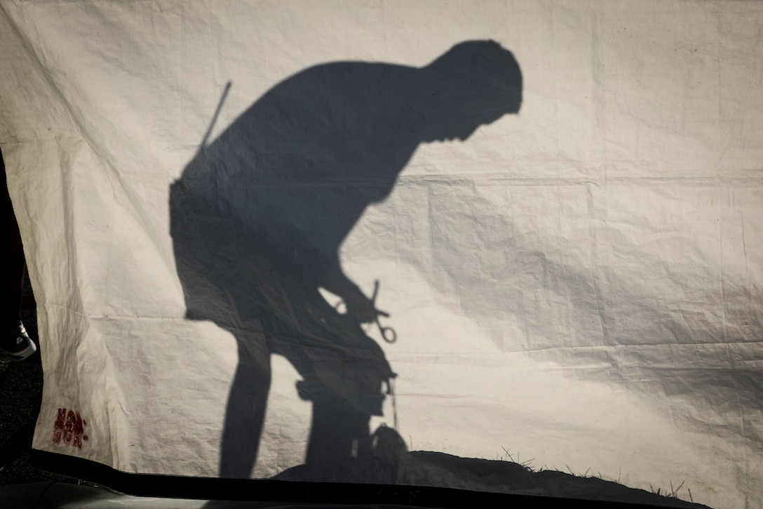 A Soldier from the 413th Chemical Company, 457th Chemical Battalion, 415th Chemical Brigade, 76th Operational Response Command cast as silhouette on a tarp as he prepares his gear before he and nearly 150 other Army Reserve Soldiers conducted a mass casualty decontamination training event Sept. 28, at the Jacobi Medical Center, Bronx, New York.  The event was part of a two-day consequence management training event focused on mass casualty decontamination, CBRN reconnaissance and medical operations along side multiple civilian agencies in and around New York City. The event involved various scenarios including rescuing patients from a Subway disaster and decontamination operations at a local hospital. (Official U.S. Army Reserve photo by Sgt. 1st Class Brent C. Powell)