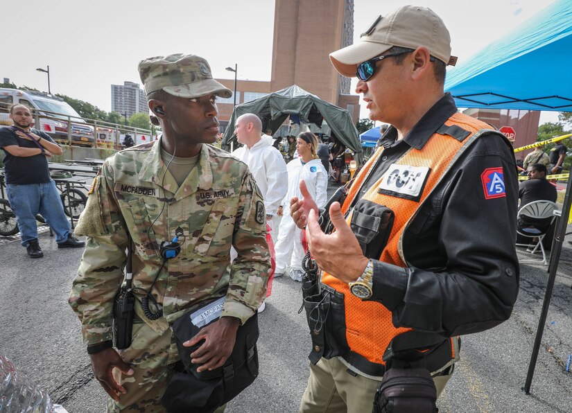 Army Reserve Staff Sgt. Jeffrey McFadden (left), a noncommissioned officer-in-charge of site management and native of Columbia, South Carolina, assigned to the 413th Chemical Company, 457th Chemical Battalion, 415th Chemical Brigade, 76th Operational Response Command, listens to an Observer, Controller, Trainer (OCT) from Army North, during a mass casualty decontamination training event at the Jacobi Medical Center, Bronx, New York, Sept. 28. The event, which involved nearly 150 Army Reserve Soldiers, was part of a two-day consequence management training exercise focused on mass casualty decontamination, Chemical, Biological, Radiological and Nuclear (CBRN) reconnaissance and medical operations along side multiple civilian agencies in and around New York City. The training involved various scenarios including rescuing patients from a Subway disaster and decontamination operations at a local hospital. (Official U.S. Army Reserve photo by Sgt. 1st Class Brent C. Powell)