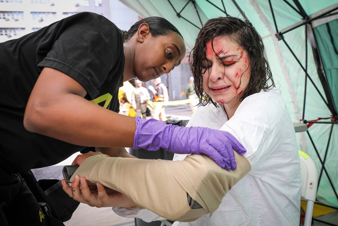 Army Reserve Spc. Azeb Hishe, a combat medic and native of Boston, Massachusetts, assigned to the 456th Medical Company (Area Support) applies a bandage to the arm of a "victim" during a mass casualty decontamination training event at the Jacobi Medical Center, Bronx, New York, Sept. 28. The event, which involved nearly 150 Army Reserve Soldiers, was part of a two-day consequence management training exercise focused on mass casualty decontamination, Chemical, Biological, Radiological and Nuclear (CBRN) reconnaissance and medical operations along side multiple civilian agencies in and around New York City. The training involved various scenarios including rescuing patients from a Subway disaster and decontamination operations at a local hospital. (Official U.S. Army Reserve photo by Sgt. 1st Class Brent C. Powell)