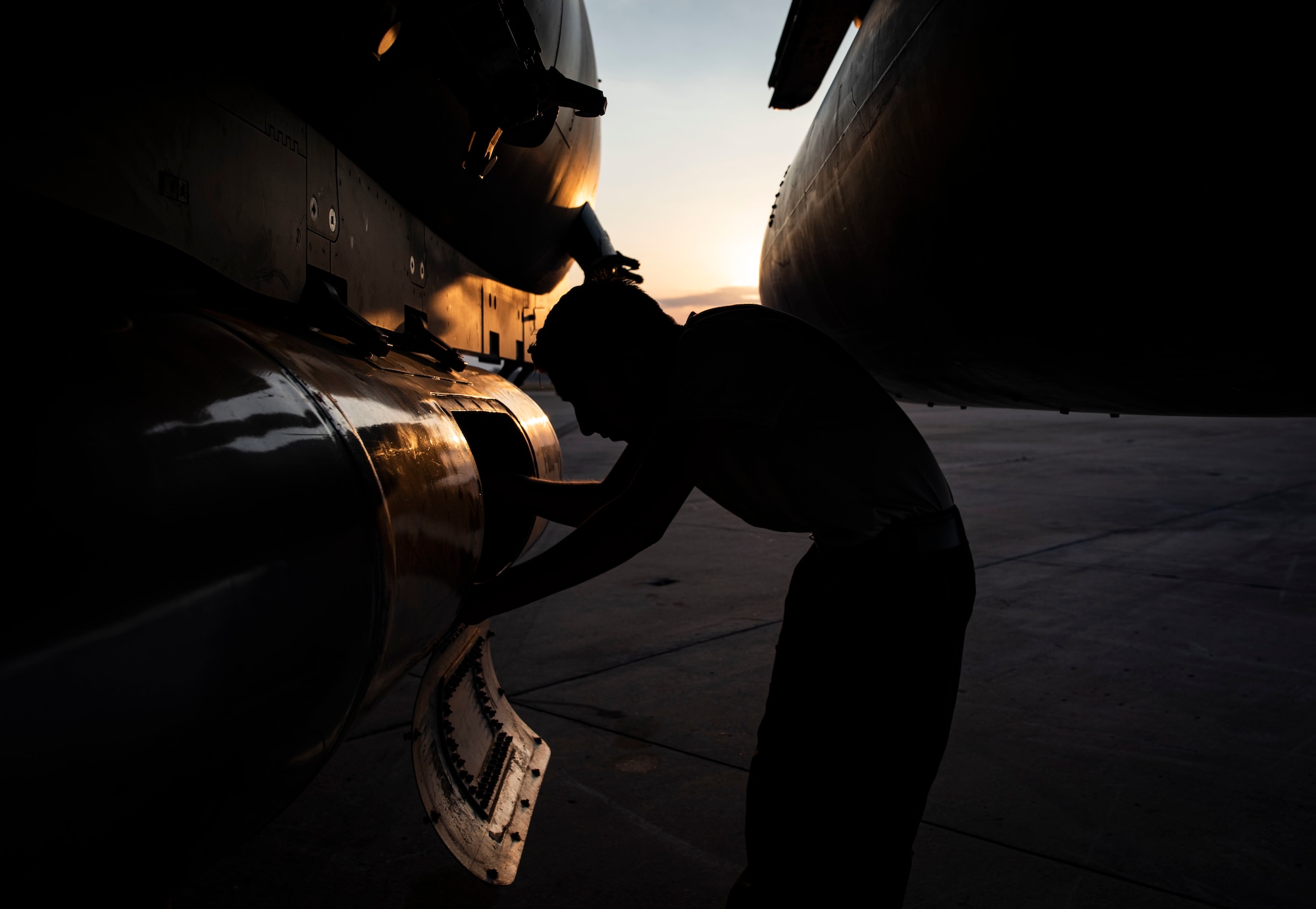 An Airman works on the flight line during sun rise.
