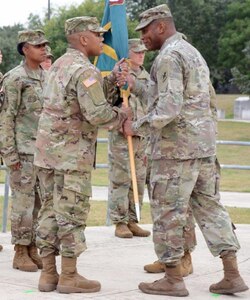 Command Sgt. Maj. Napoleon Noguerapayan passes the unit colors to Maj. Gen. Patrick D. Sargent during the MEDCoE change of responsibility ceremony.