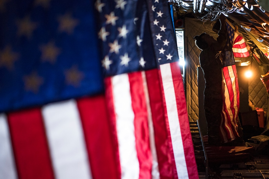 Pilot hangs the American flag inside a KC-135 Stratotanker