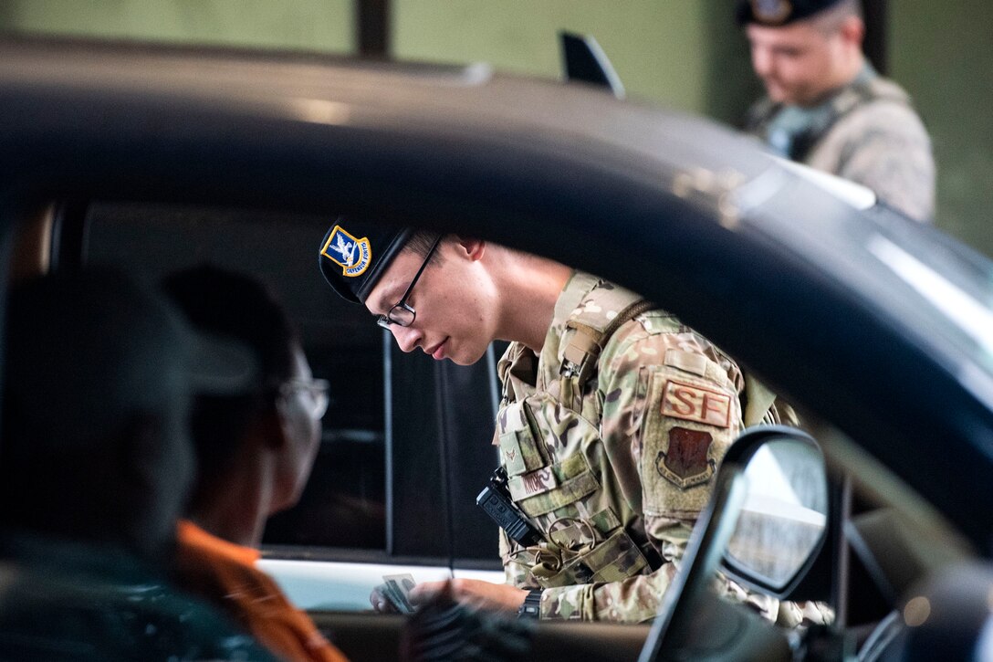 Airman 1st Class Steven Knox, 23d Security Forces Squadron installation entry controller, verifies a retiree’s ID card Oct. 2, 2019, at Moody Air Force Base, Ga. Installation entry controllers serve as the first line of defense, keeping Moody’s assets and personnel safe from potential threats. (U.S. Air Force photo by Senior Airman Erick Requadt)