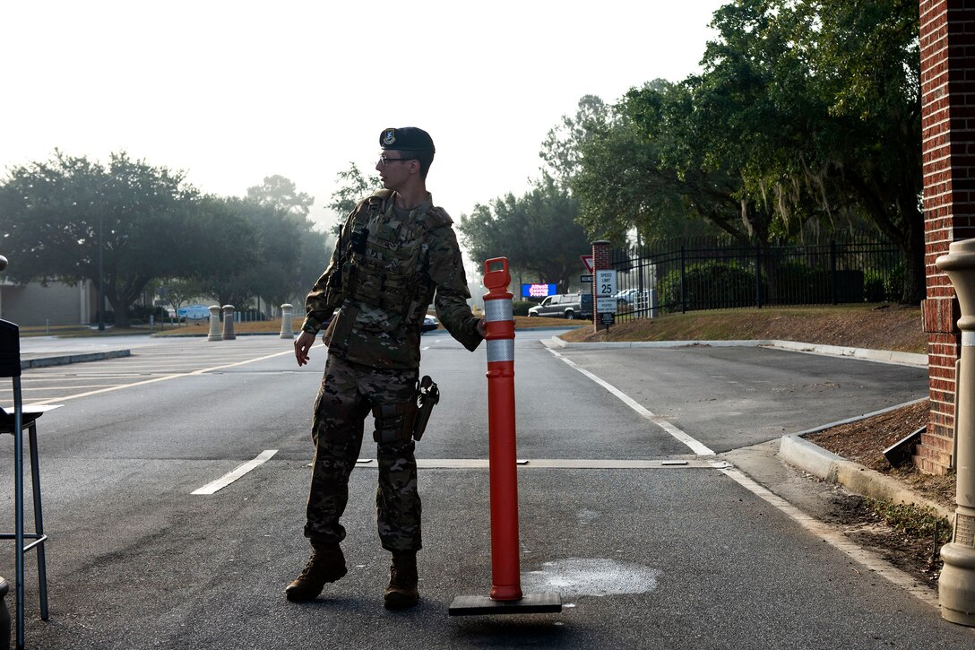 Airman 1st Class Steven Knox, 23d Security Forces Squadron installation entry controller, places a safety cone in a gate lane Oct. 2, 2019, at Moody Air Force Base, Ga. Installation entry controllers serve as the first line of defense, keeping Moody’s assets and personnel safe from potential threats. (U.S. Air Force photo by Senior Airman Erick Requadt)