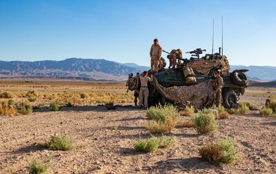 U.S. Marines with 3rd Light Armored Reconnaissance Battalion, 1st Marine Division, camouflage a Light Armored Vehicle during a Marine Corps Combat Readiness Evaluation (MCCRE) at Marine Corps Air Ground Combat Center Twentynine Palms, California, Sept. 6, 2019. The MCCRE is used to formally evaluate Marines on their combat readiness prior to their upcoming deployment. (U.S. Marine Corps photo by Lance Cpl. Roxanna Ortiz)