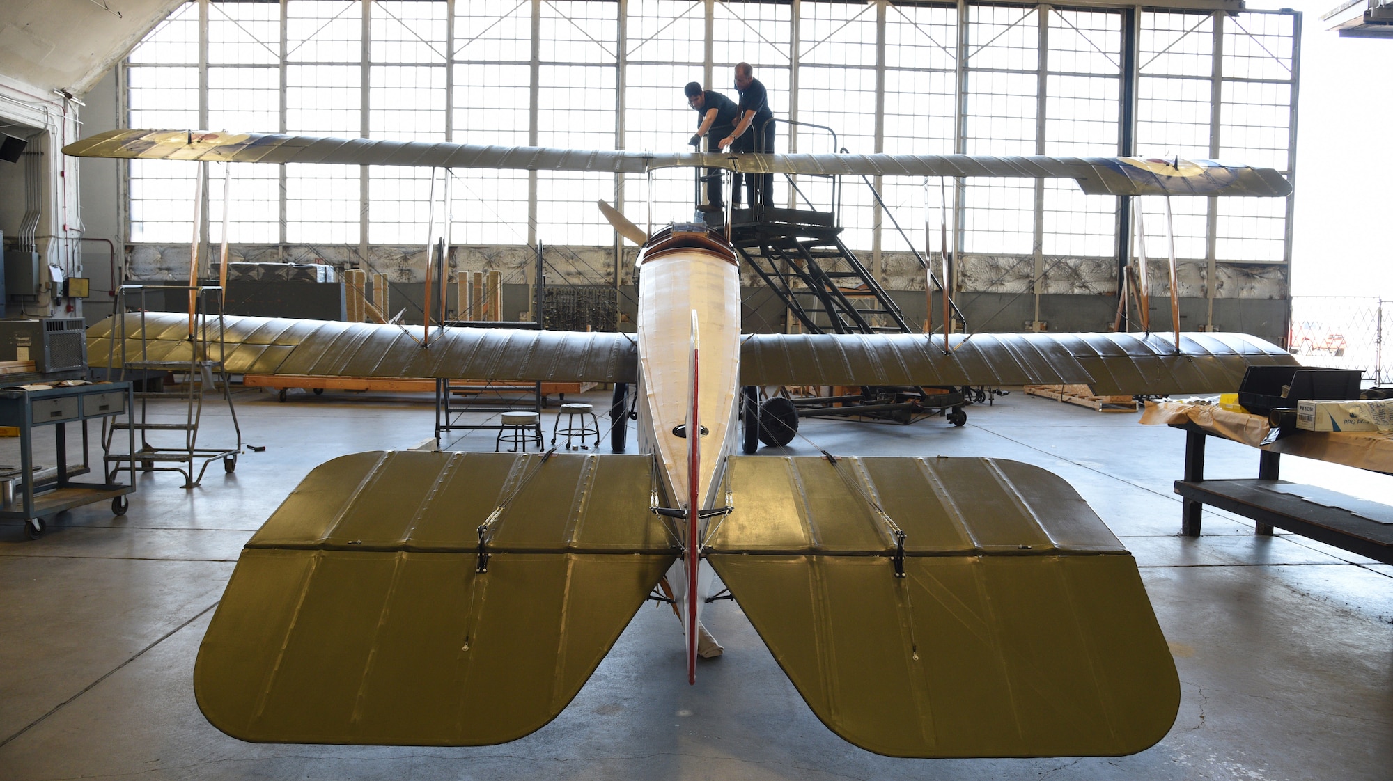 Top wing of biplane being worked on during restoration.